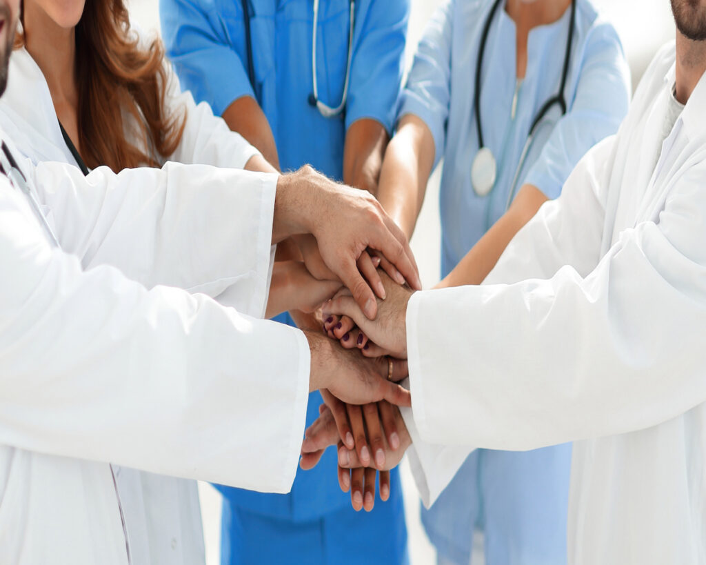 Doctors and nurses stacking hand