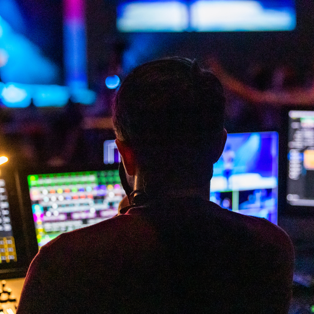 man in front of several computer screens , quality monitoring, agent assisting, cusotmer support